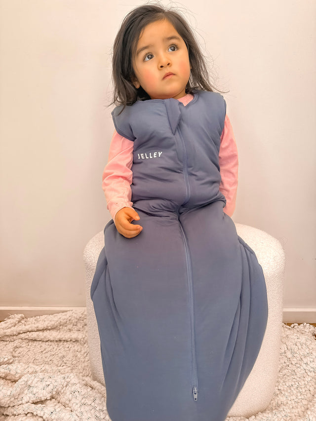 Toddler wearing Jelley silver fibre sleeping bag in navy colour.