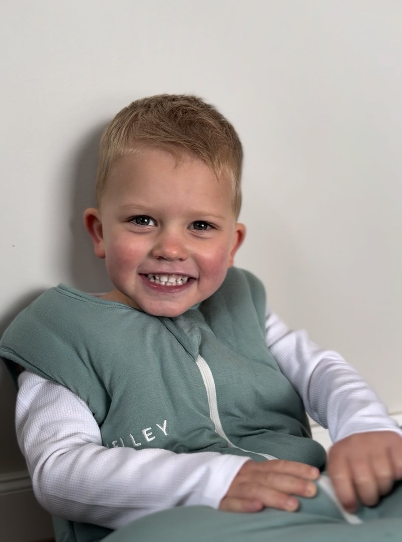 Toddler wearing Jelley silver fibre sleeping bag in sage colour.